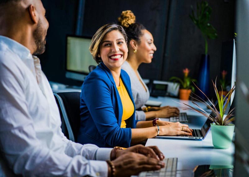 Woman smiling at her colleagues, preparing to transition to partnerships